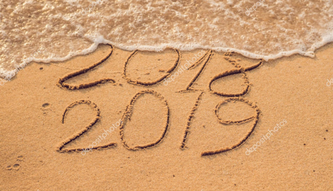 New Year 2019 is coming concept - inscription 2018 and 2019 on a beach sand, the wave is almost covering the digits 2018